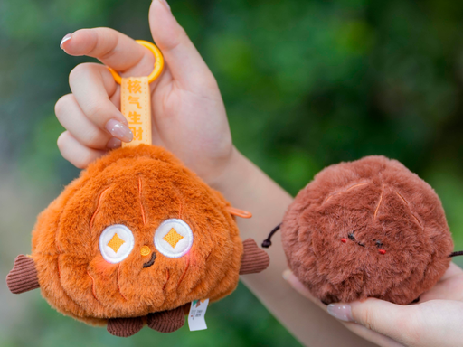 Two soft character charms held outdoors
