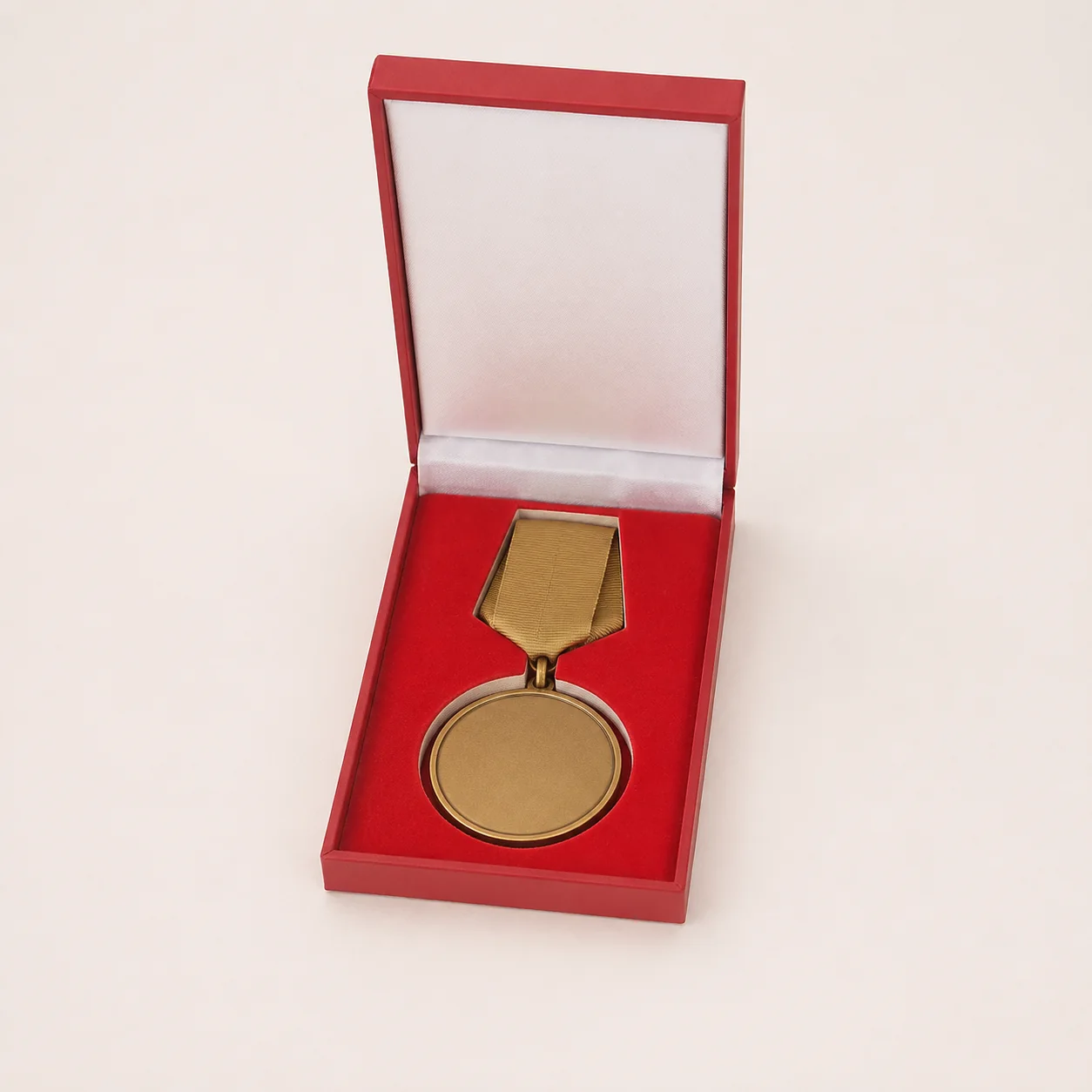 Red rectangular presentation box holding a medal and ribbon
