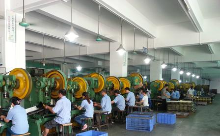 Workers operating a row of presses in the factory